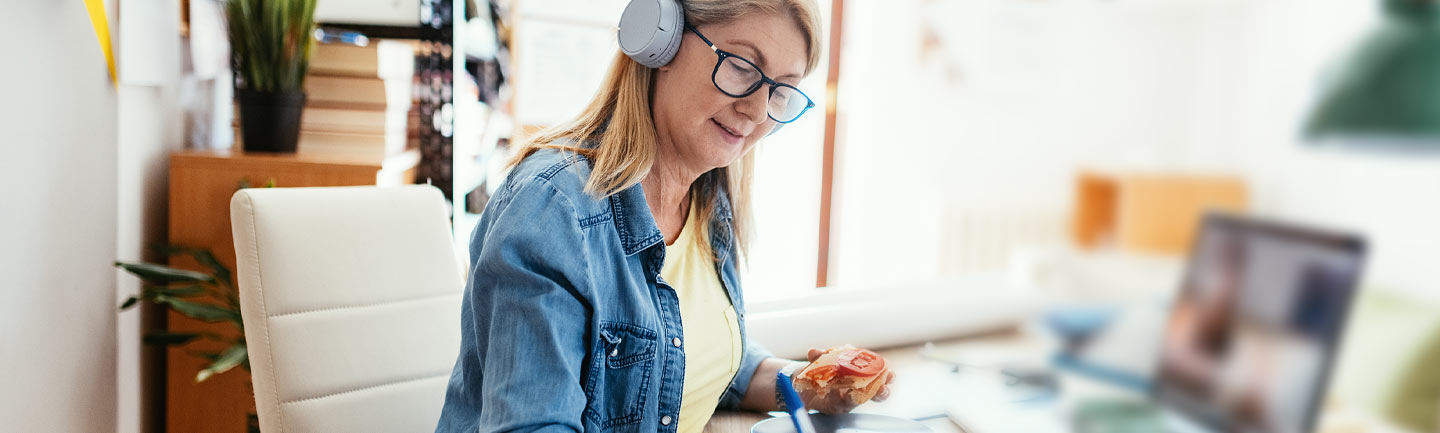 Woman sitting at her laptop with headphones on