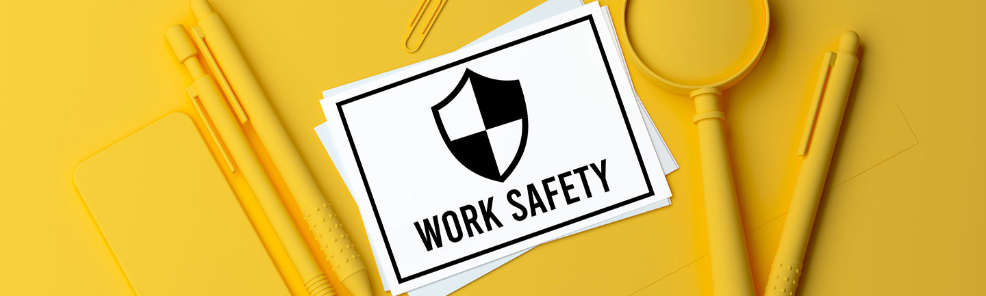 Yellow table with a collection of yellow objects on it and a white piece of paper that says "Work Safety"