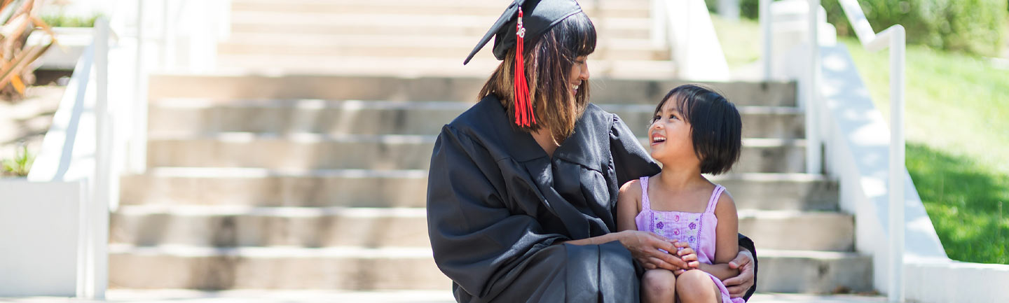 Graduate sitting on steps with her daughter
