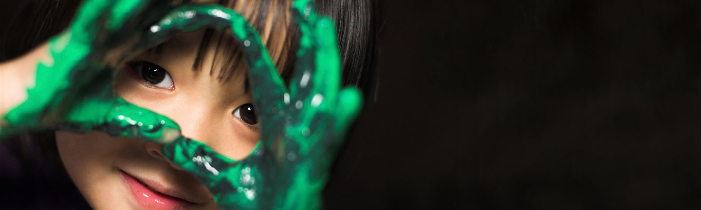 Young girl with green paint on her hands