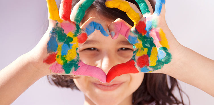 A happy young girl wih paint on her hands