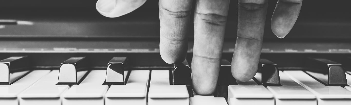 Up close photo of a hand playing a piano
