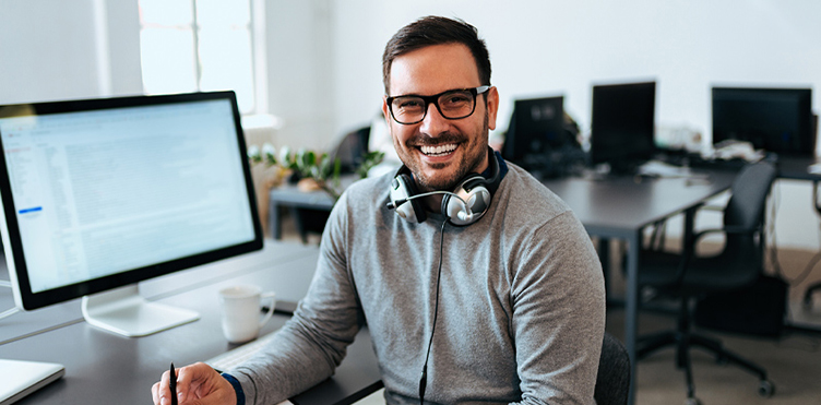 Young professional smiling while sitting at his desk