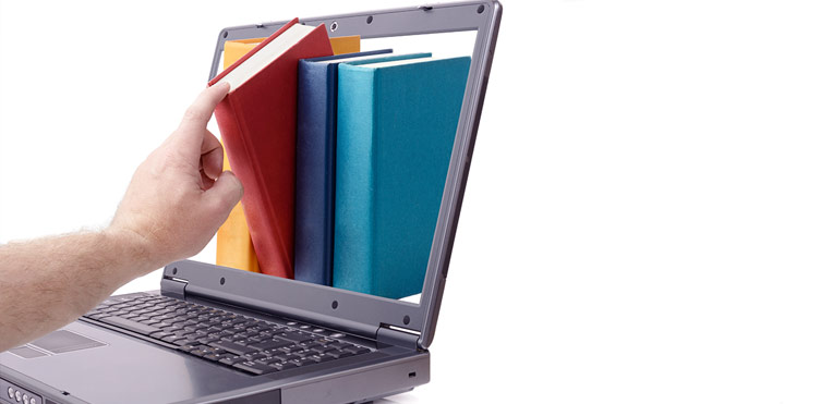 A hand pulling a book out of a laptop screen