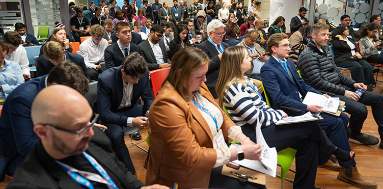 A group of people listening to a presentation. 