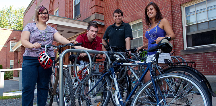A group of students stand with their bikes on the UNB Fredericton campus