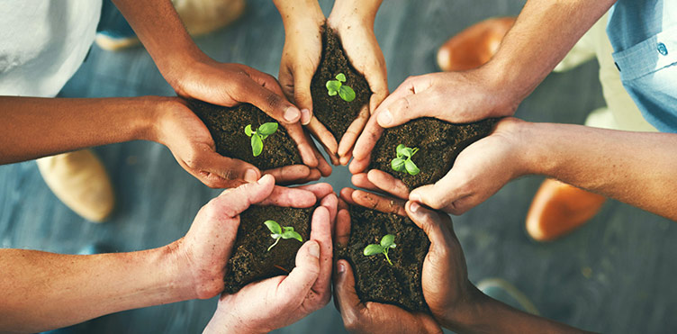 Photo of people standing in a circle with hands together