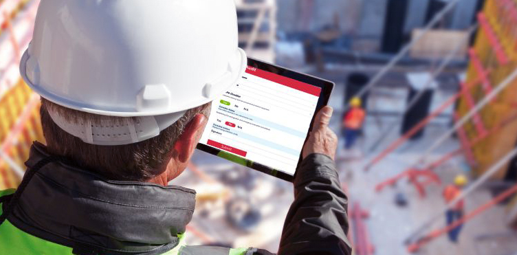 Construction site supervisor reviewing digital building plans on a tablet.