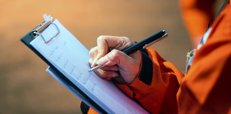 A worker takes notes while on-site.