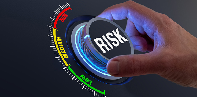 Hand adjusting a risk control dial, representing risk assessment and management in workplace safety.