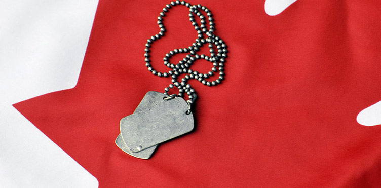 Military identification tags set on the Canadian Maple Leaf of the Canadian flag.