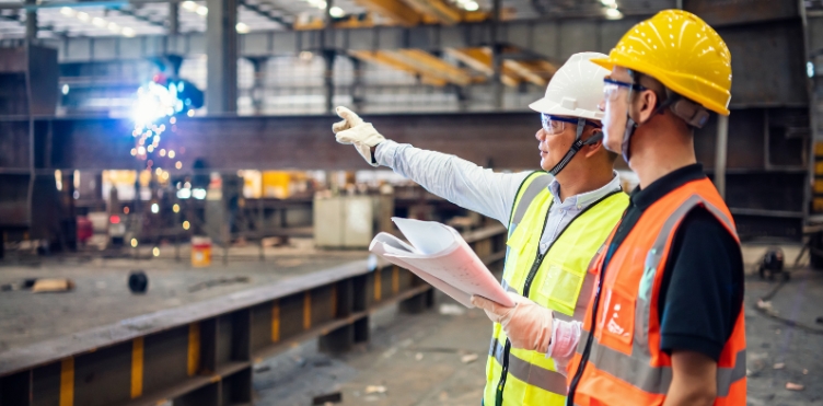 This is a photo of two inspectors working in a steel factory.