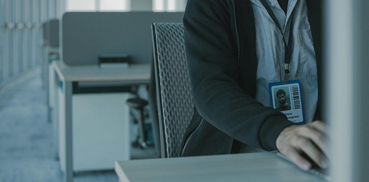 A photo of an individul working at a desktop computer